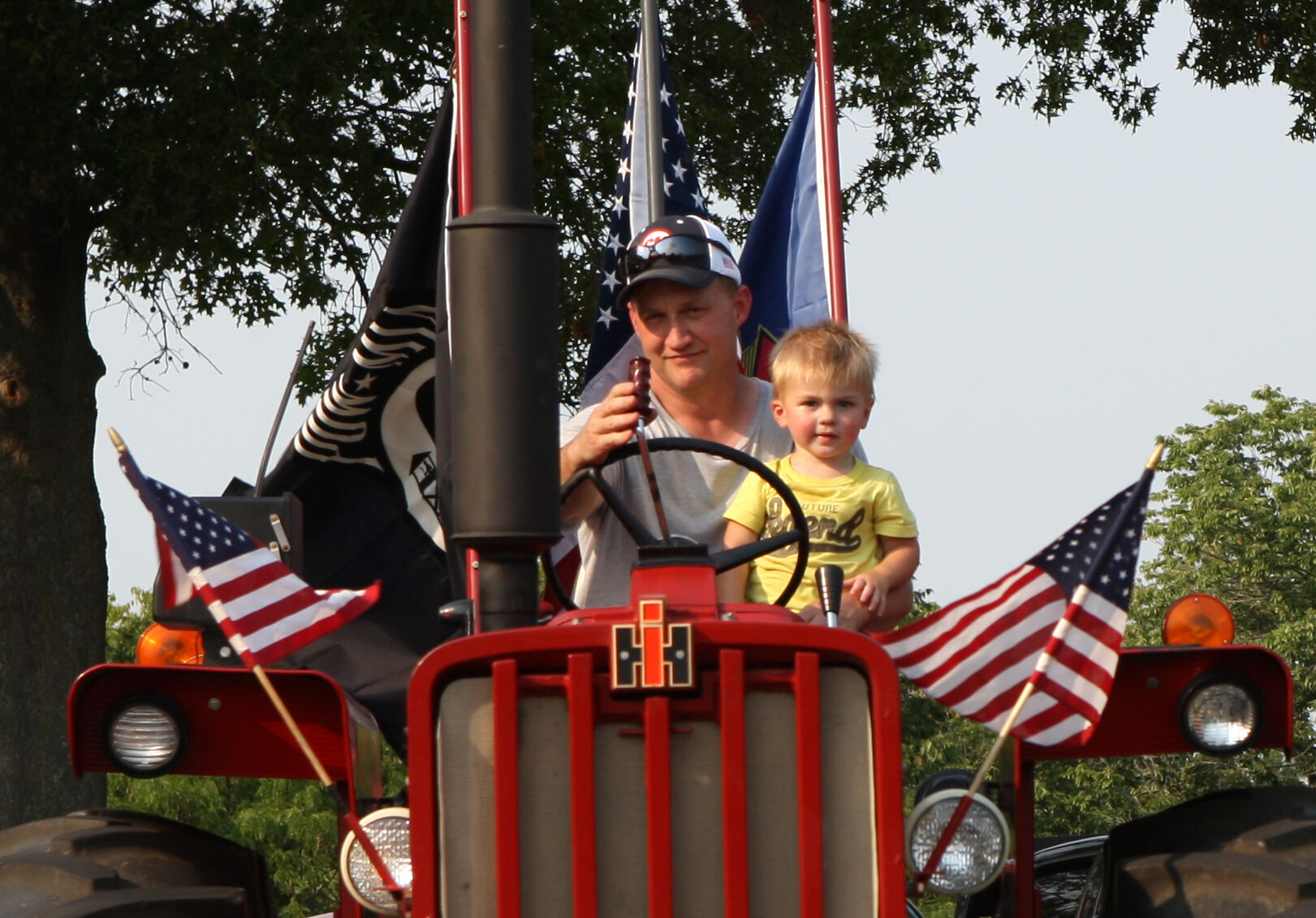Tom Bruckerhoff holds Levi Waelder on a tractor